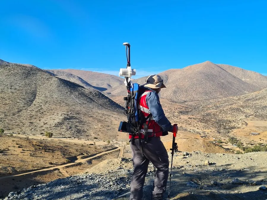 Operador desplazándose en terreno con instrumento de levantamiento geofísico